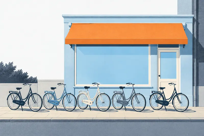Een rij stadsfietsen op de stoep voor onze winkel, onder een oranje luifel